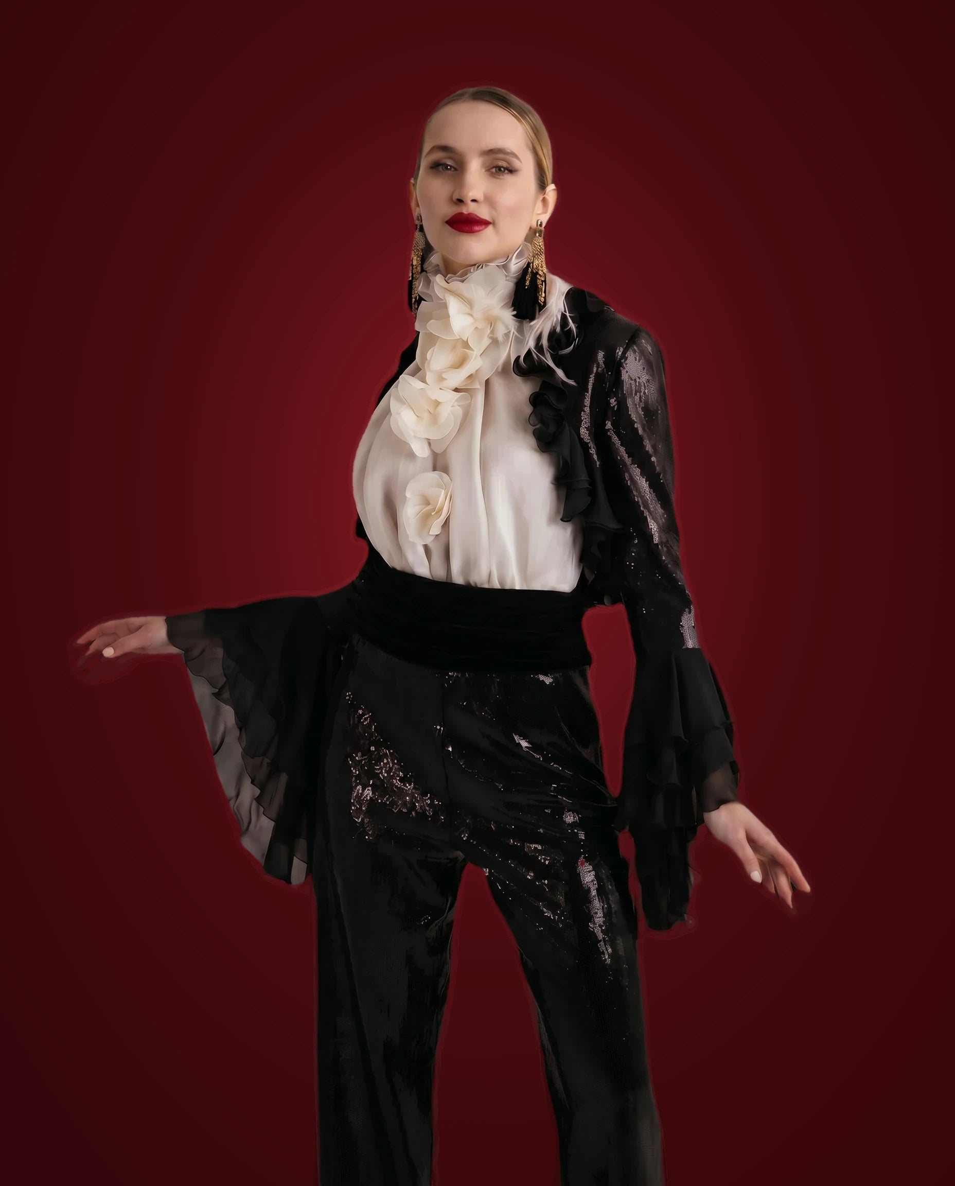 Black sequin trousers with ivory ruffled blouse and black chiffon bolero, front view, sleeves extended