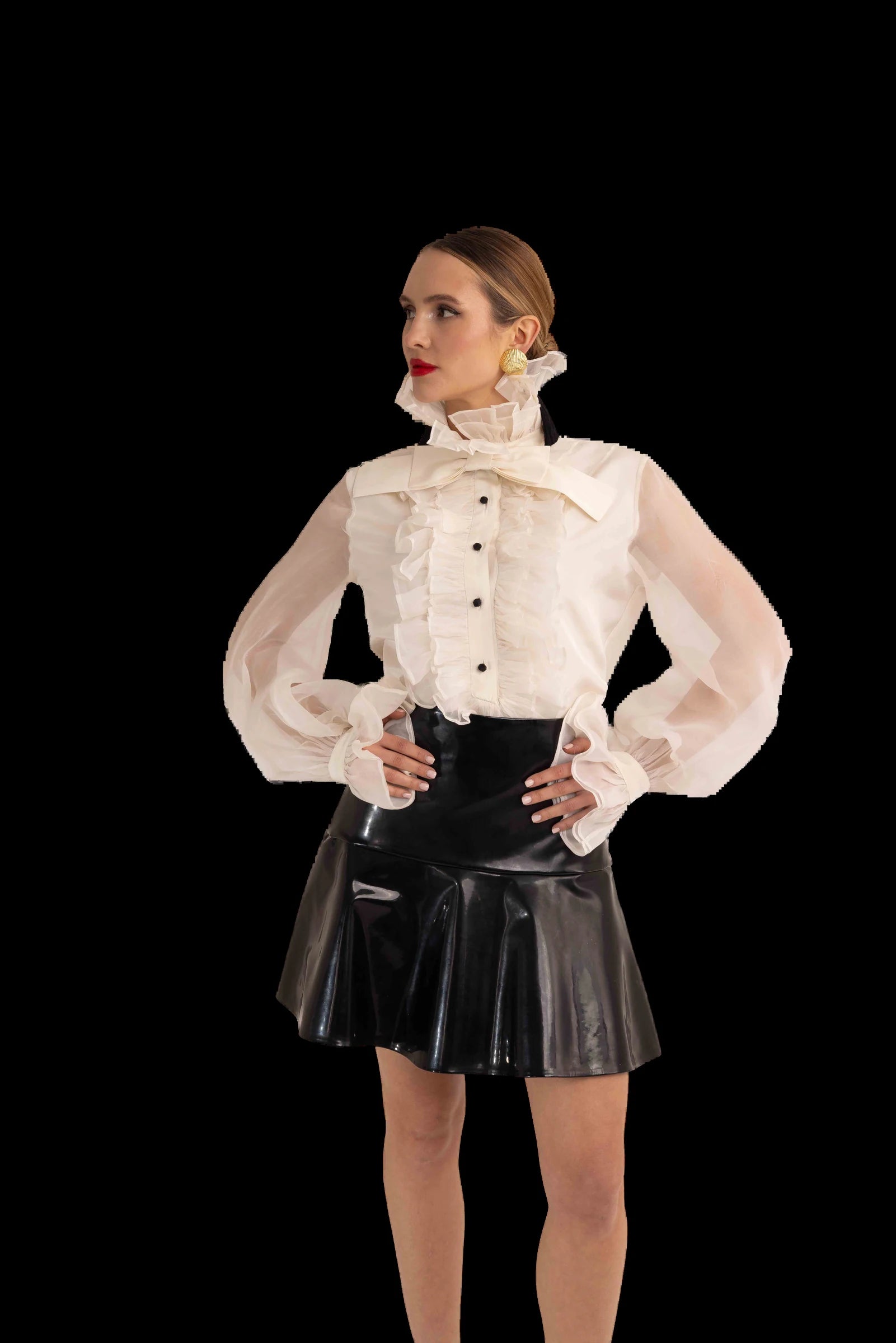 Ivory organza ruffled blouse with black patent flared mini skirt, front view, hands at waist