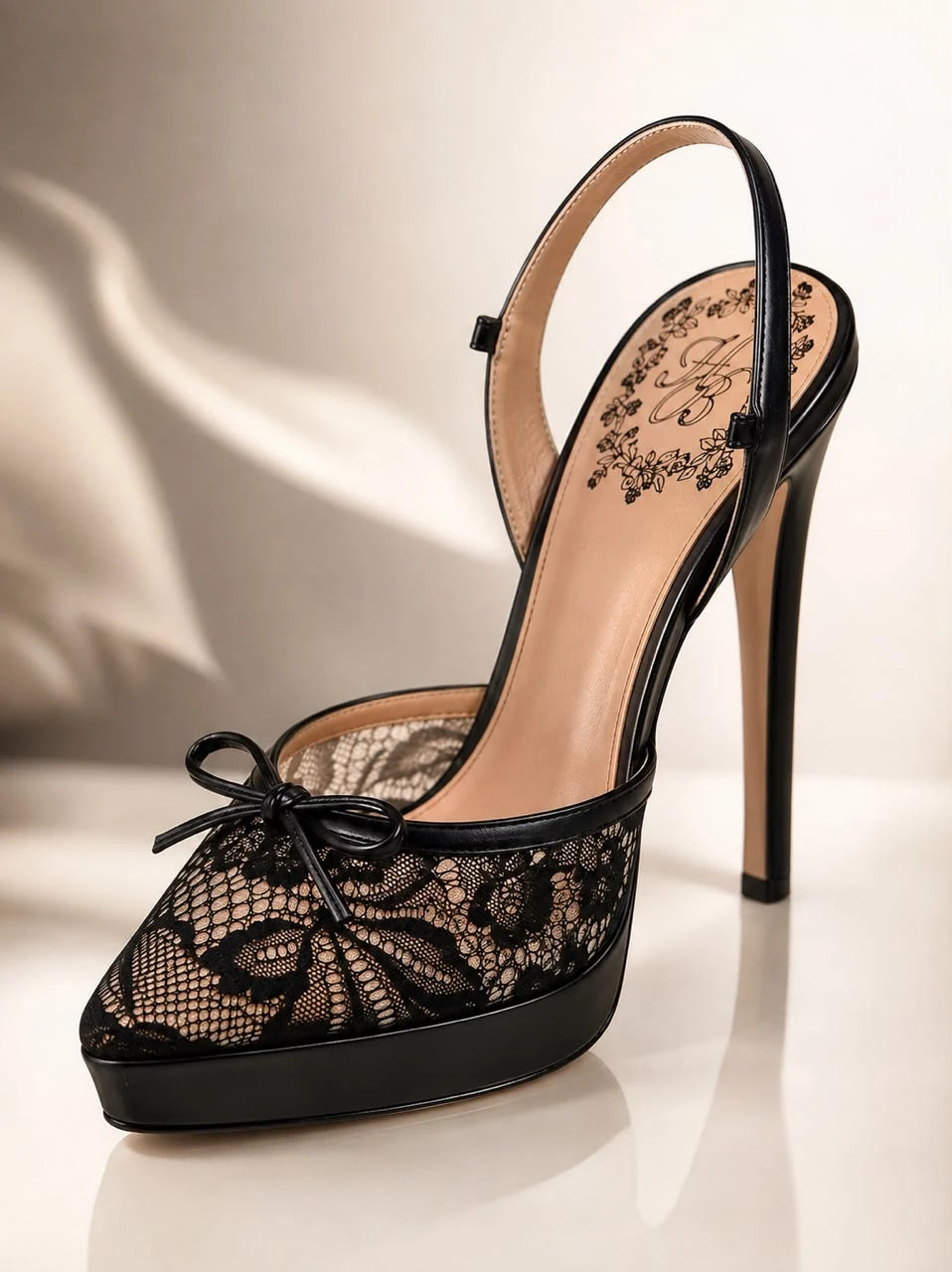 Black Lace Slingback by Maison Hanan, a pointed-toe slingback in black floral lace over a nude lining with a small bow and a black platform sole.