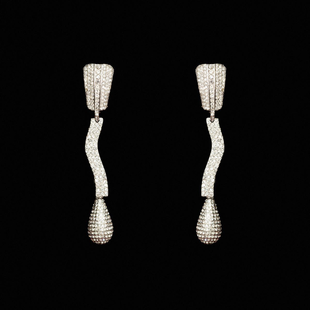 Sculptural silver-tone drop earrings with a wave-shaped crystal pave bar and teardrop