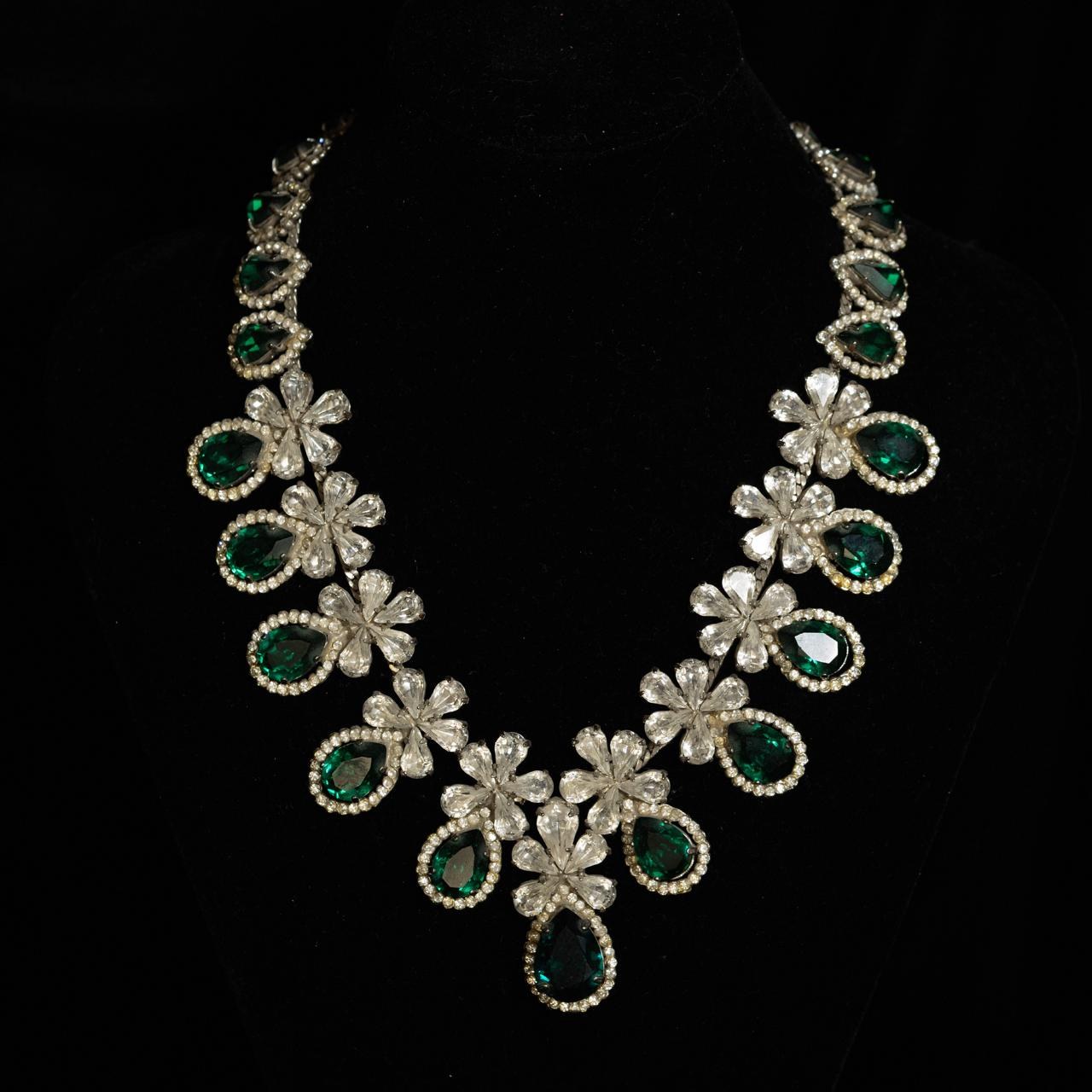 Silver-tone necklace of clear crystal flowers with green pear-cut crystals between them