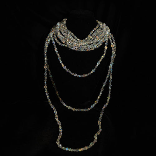 Multi-strand necklace of small iridescent crystal beads twisted at the throat