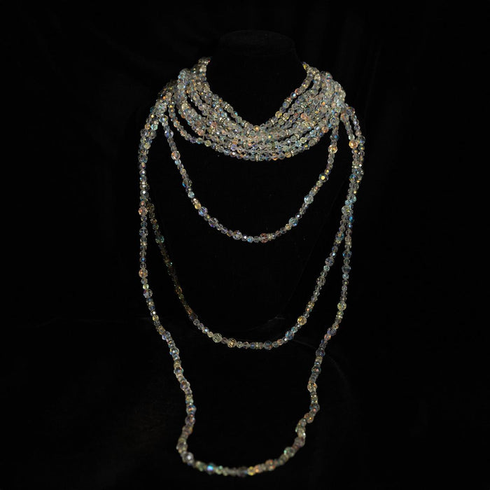 Multi-strand necklace of small iridescent crystal beads twisted at the throat