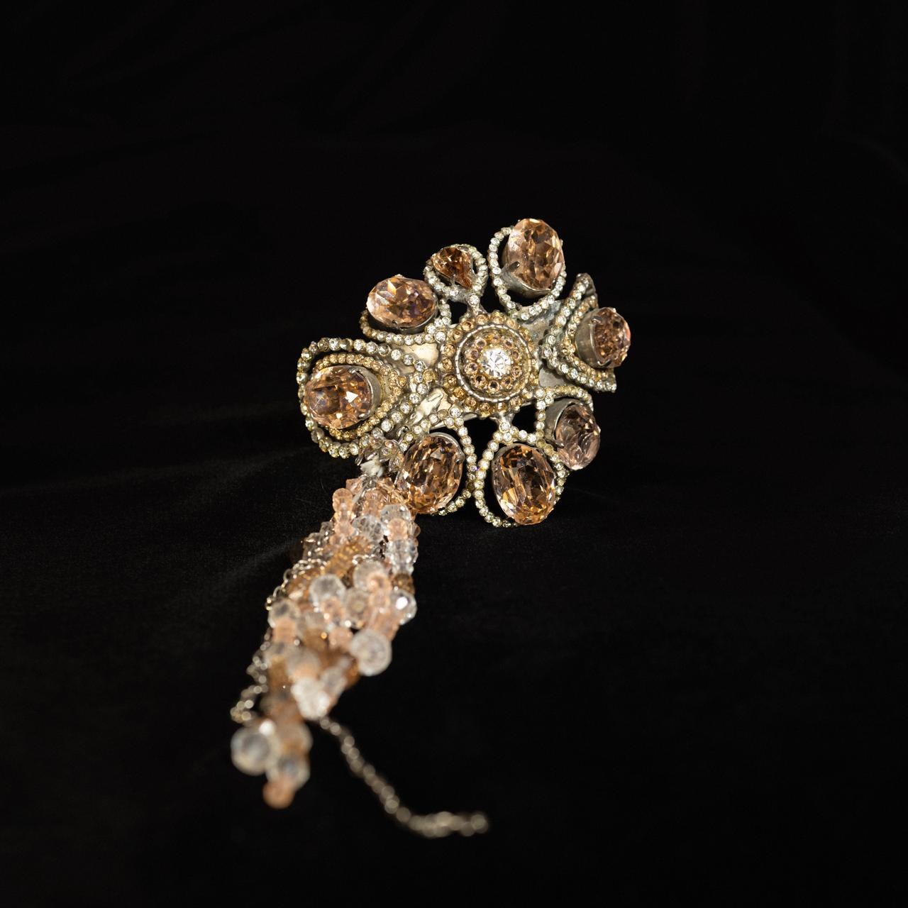 Rigid crystal cuff bracelet with a champagne rosette and a cascade of blush beads