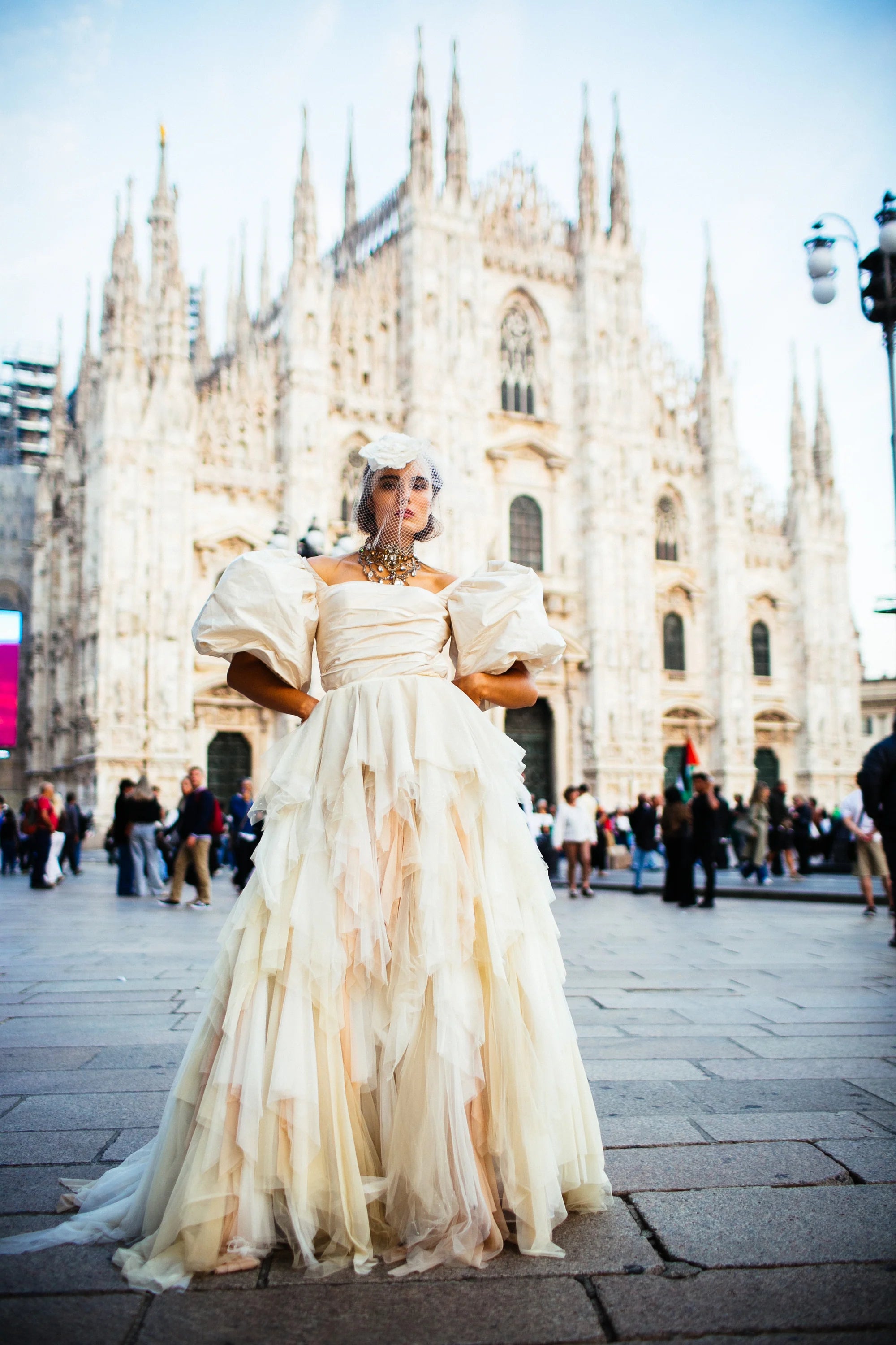 An ivory tulle ballgown with full puff sleeves, photographed in the piazza before the Duomo, Milan.