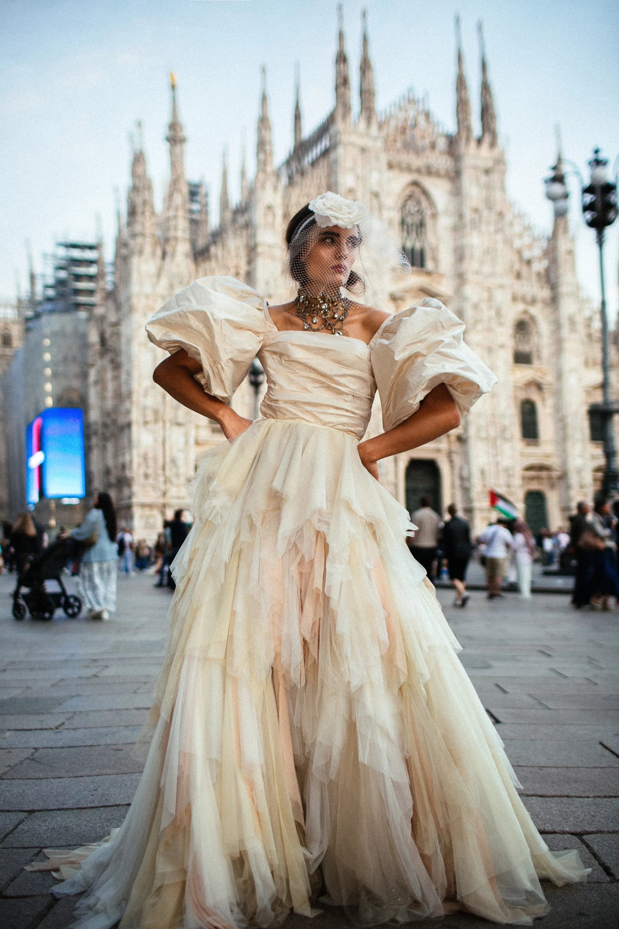 An ivory tulle ballgown with full puff sleeves, photographed in the piazza before the Duomo, Milan.