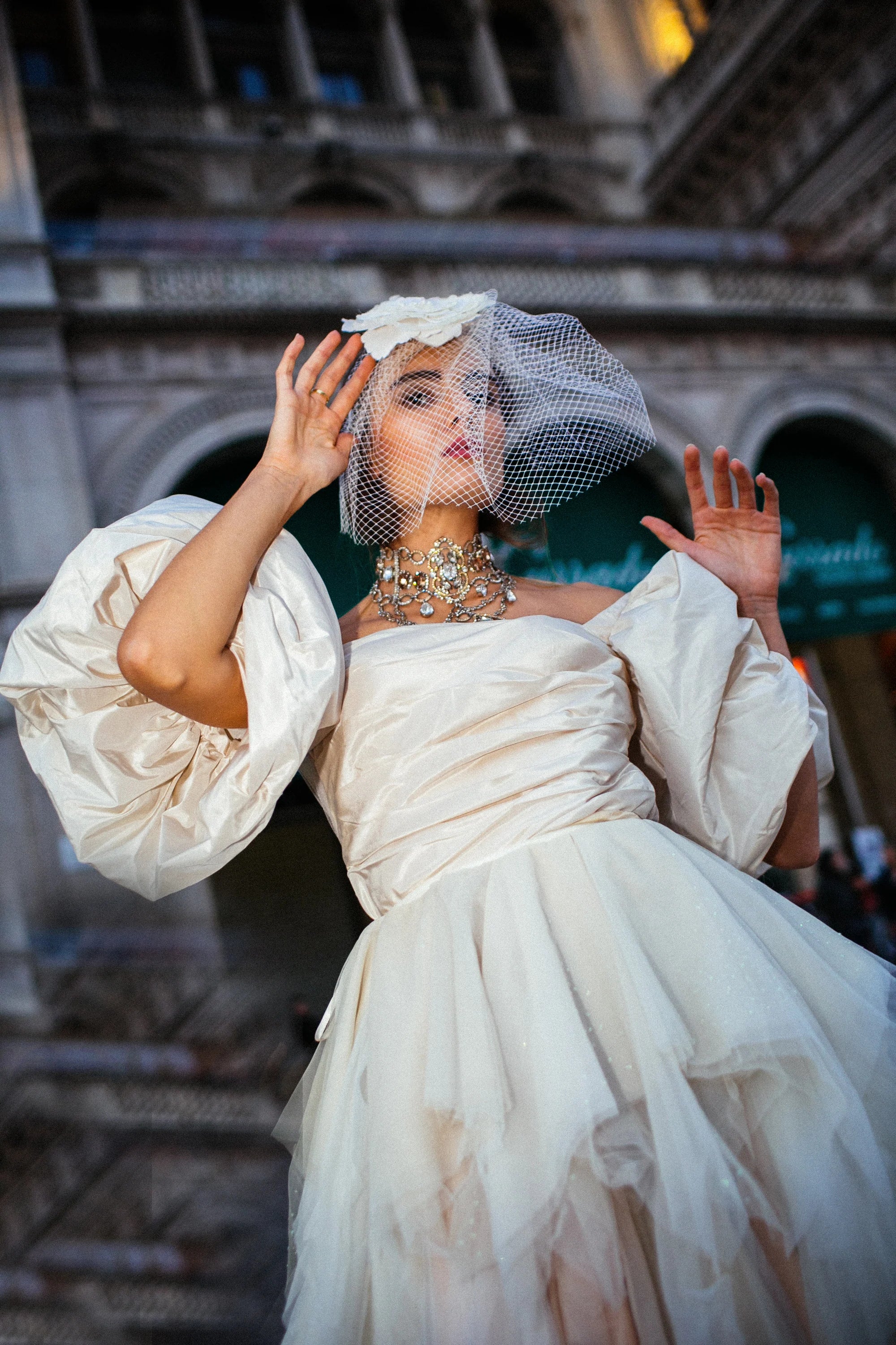An ivory tulle ballgown with full puff sleeves, photographed in the piazza before the Duomo, Milan.