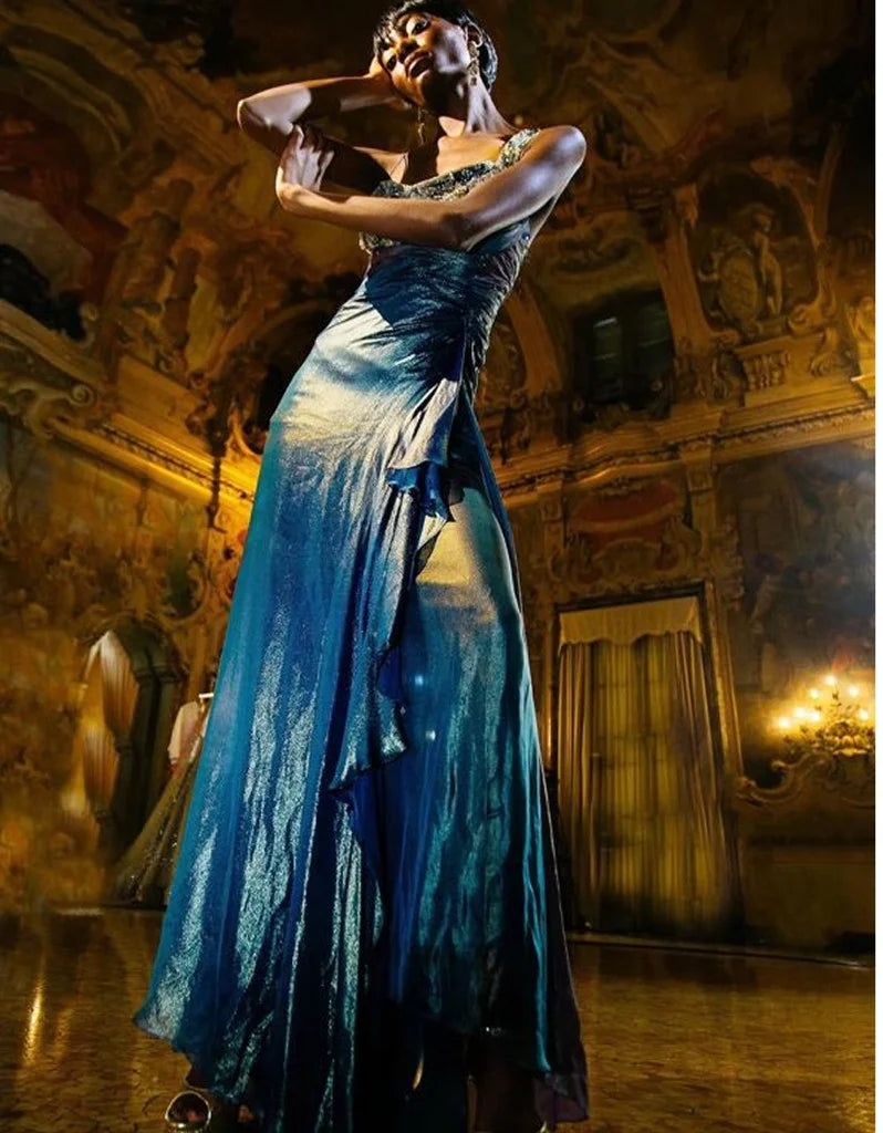 A blue silk gown with a ruffled front, photographed in a frescoed and gilded hall.