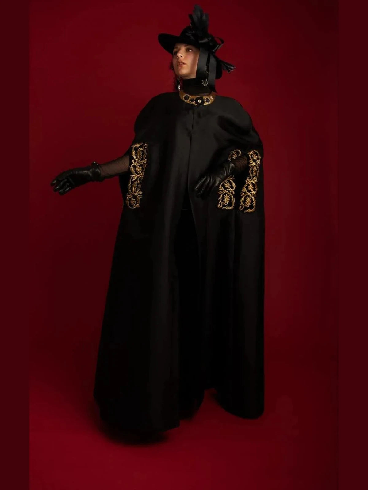 An embroidered abaya worn open over a black dress.